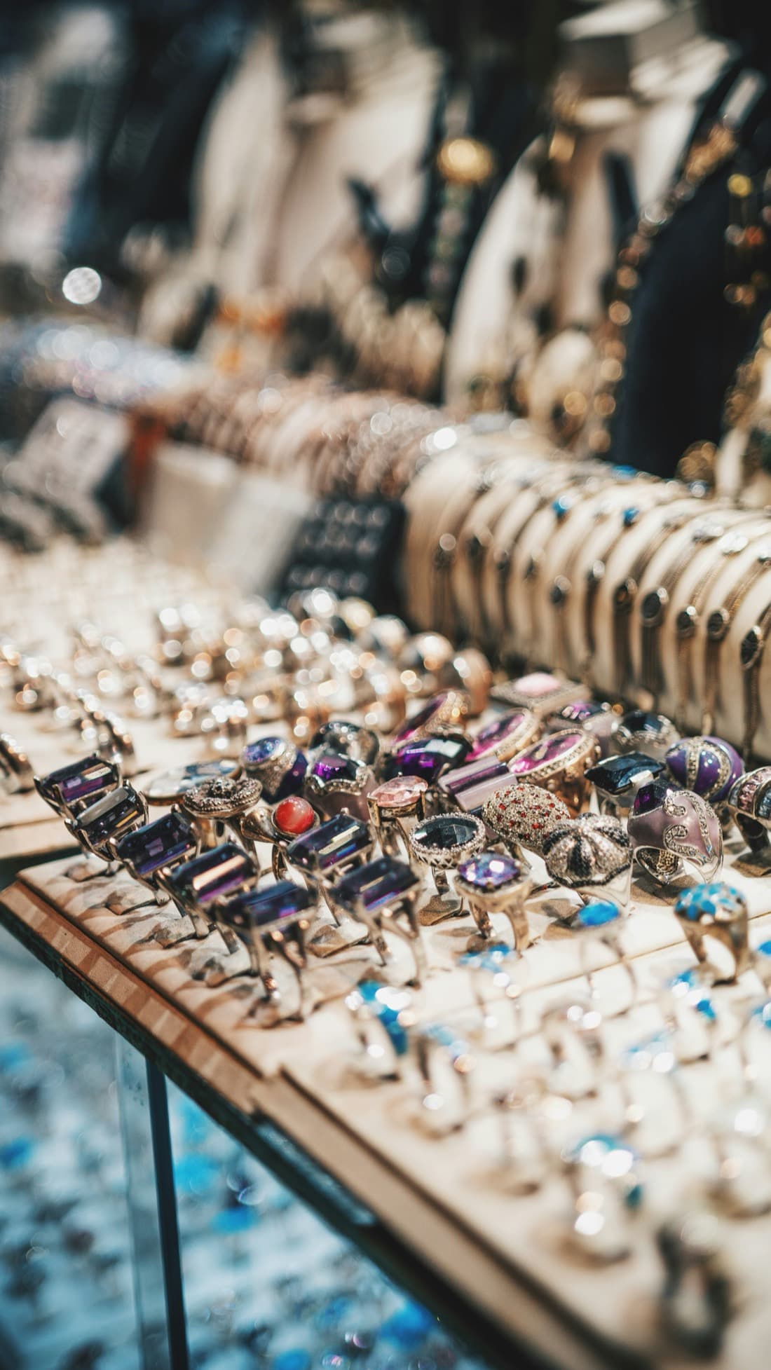 A market table covered in vintage cocktail rings with colored stones